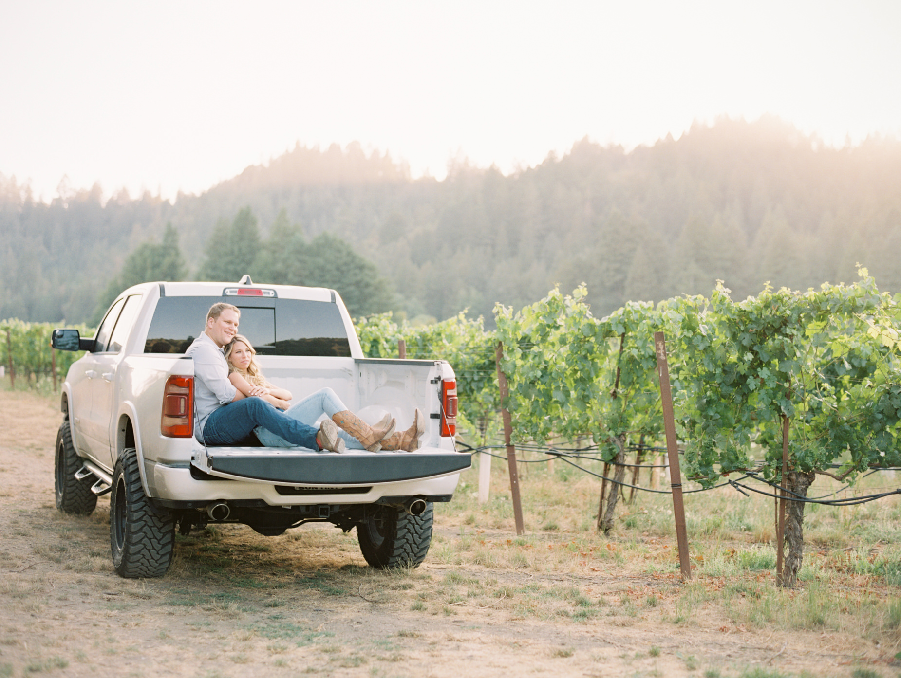 Jeff and Heather sitting in white pickup truck during vineyard engagement at Williams Selyem Wines