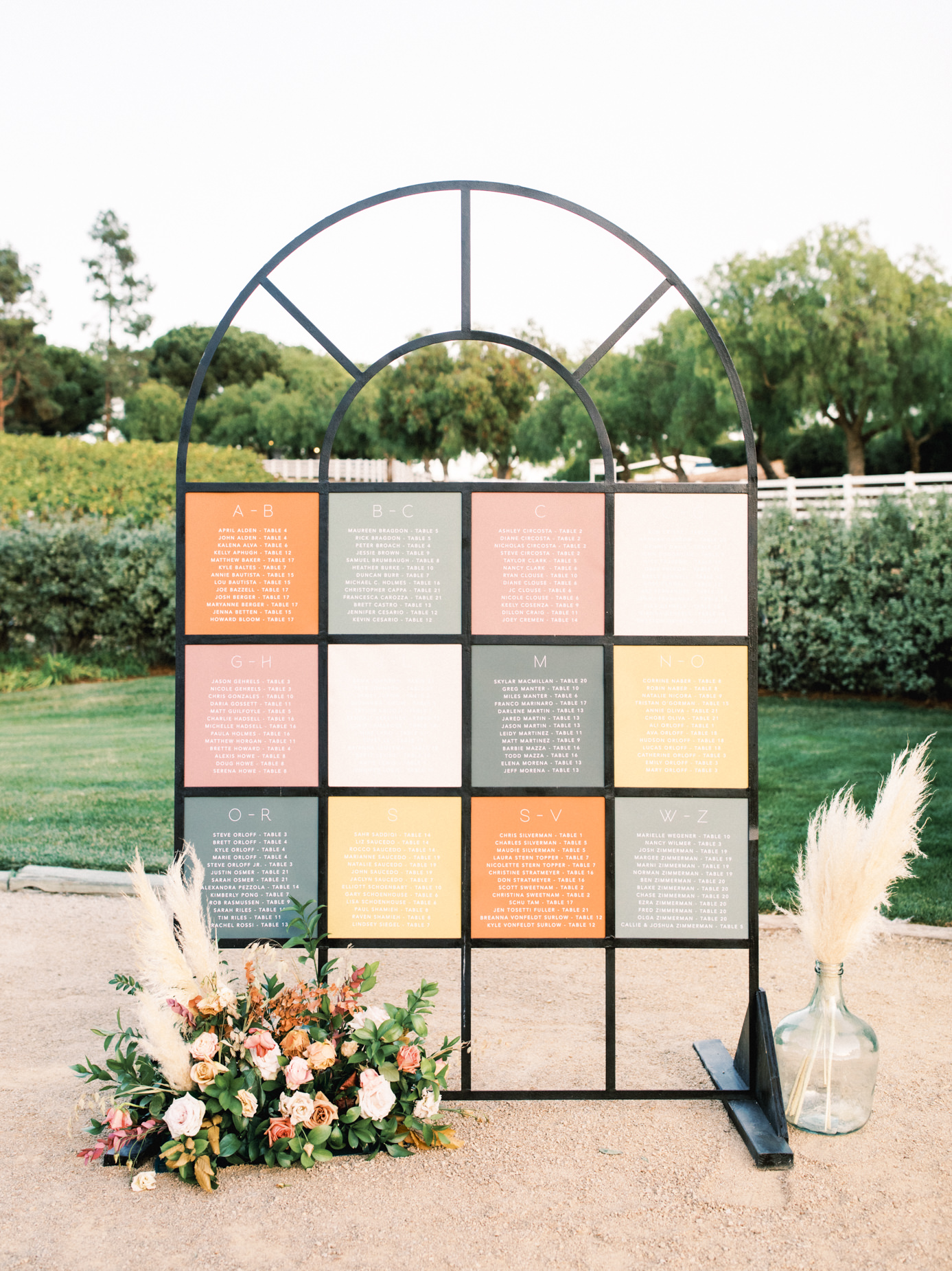 Unique and colorful seating chart signage with flowers at Greengate Ranch wedding